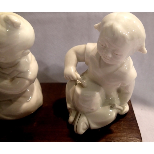 379 - Three Oriental ceramic musician figurines on a wooden base, each H: 11 cm. P&P Group 2 (£18+VAT for ... 