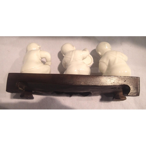 379 - Three Oriental ceramic musician figurines on a wooden base, each H: 11 cm. P&P Group 2 (£18+VAT for ... 