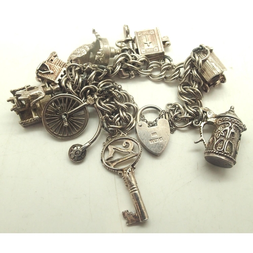 51 - Hallmarked silver charm bracelet with padlock clasp and nine charms, combined 43g. P&P Group 1 (£14+... 