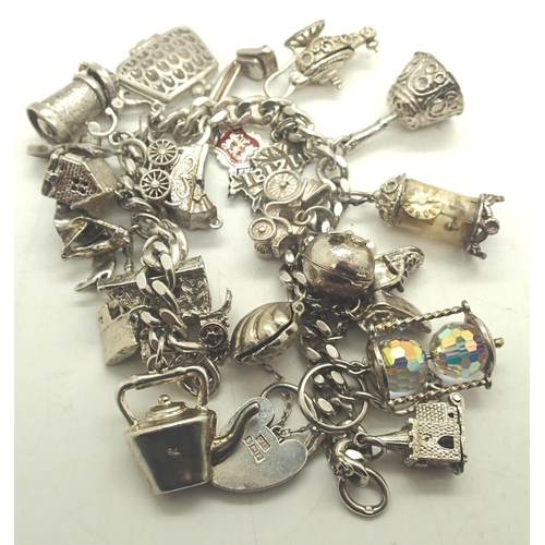 51a - Hallmarked silver charm bracelet with 24 charms, L: 16 cm, combined 106g. Charms unmarked. P&P Group... 