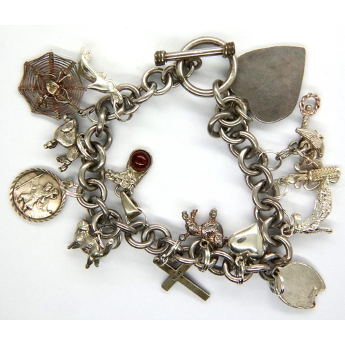 11 - 925 silver charm bracelet with fourteen charms, L: 19 cm, 56g. P&P Group 1 (£14+VAT for the first lo... 