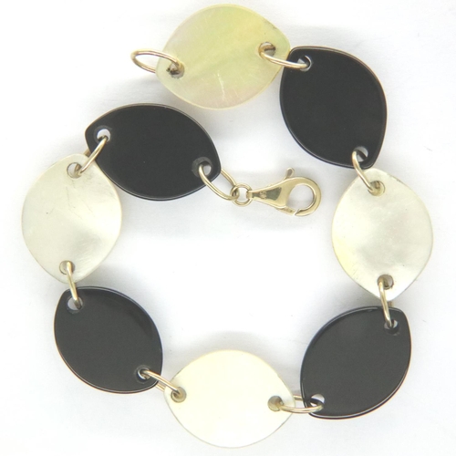 31 - Contemporary bracelet formed with alternating panels of onyx and mother pearl with 9ct gold clasp an... 