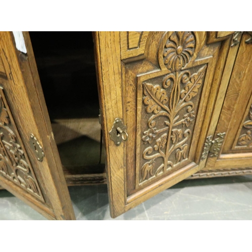 3131 - Early 20th century oak cabinet, heavily carved in the Jacobean manner, having three short drawers an... 