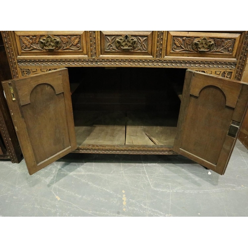 3131 - Early 20th century oak cabinet, heavily carved in the Jacobean manner, having three short drawers an... 