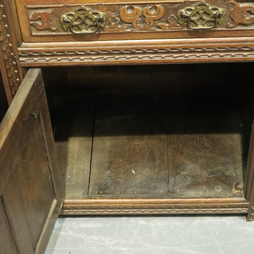 3132 - Early 20th century oak cabinet, heavily carved in the Jacobean manner, having a single cupboard door... 