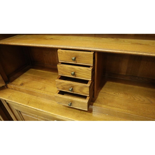 3103 - A substantial fruitwood bookcase with glazed doors enclosing adjustable shelves and drawers raised o... 