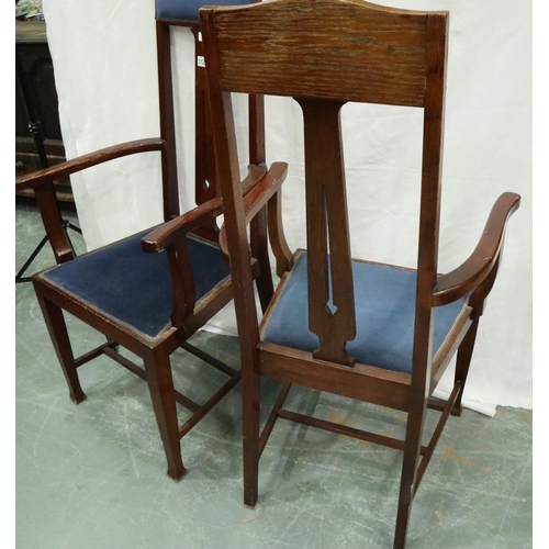 3128 - A pair of oak framed Arts and Crafts period elbow chairs, each with upholstered seat and headrest, e... 