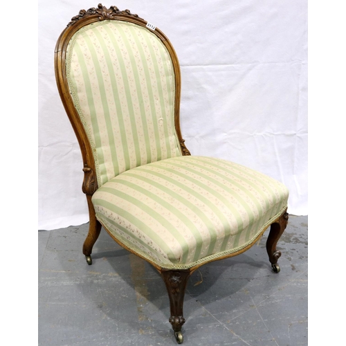 3112 - A Victorian walnut framed parlour chair with upholstered seat and backrest, low seated and brass cas... 