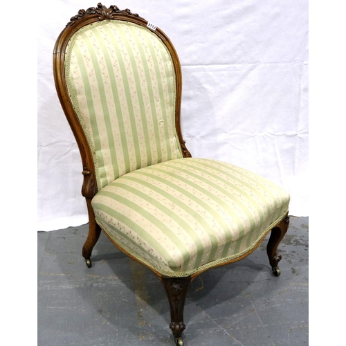 3112 - A Victorian walnut framed parlour chair with upholstered seat and backrest, low seated and brass cas... 