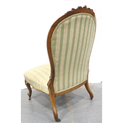 3112 - A Victorian walnut framed parlour chair with upholstered seat and backrest, low seated and brass cas... 