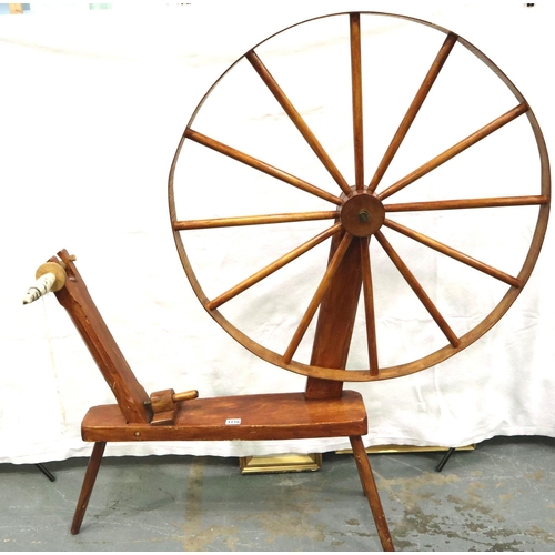 3116 - A late 20th century spinning wheel in pine with pegged joints and raised on three supports, overall ... 