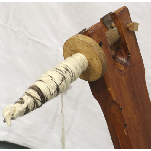 3116 - A late 20th century spinning wheel in pine with pegged joints and raised on three supports, overall ... 