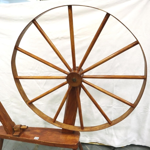 3116 - A late 20th century spinning wheel in pine with pegged joints and raised on three supports, overall ... 