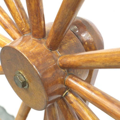 3116 - A late 20th century spinning wheel in pine with pegged joints and raised on three supports, overall ... 