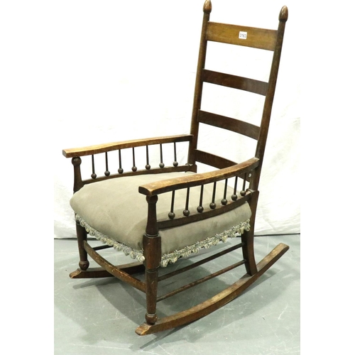 3163 - An Arts and Crafts period elm rocking chair with laddered back and spindled supports. Not available ... 