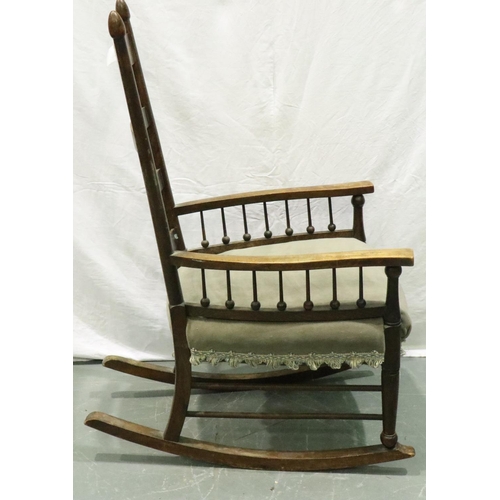 3163 - An Arts and Crafts period elm rocking chair with laddered back and spindled supports. Not available ... 