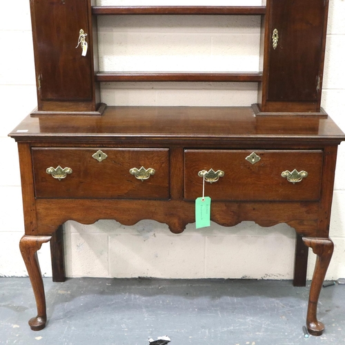 3106 - An 18th century oak dresser, the open plate rack with two cupboards sits on a base of two short draw... 