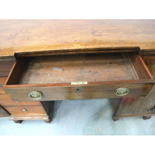 3115 - A Regency mahogany twin pedestal sideboard, each cupboard fitted with drawers and cellarette, the ce... 