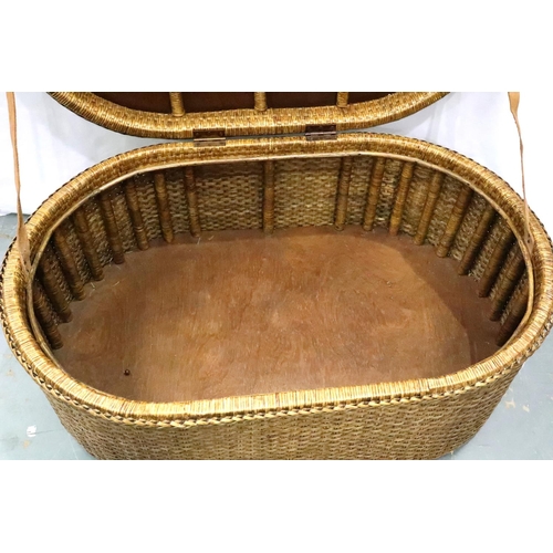 3140 - A large canework hamper of oval form, with hinged rigid lid, 110 x 71 x 45 cm H. Not available for i... 