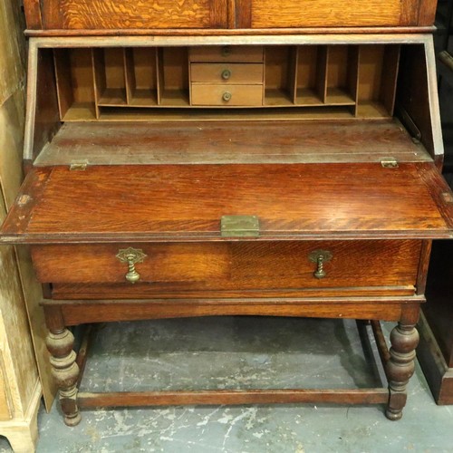 3154 - A late 19th century oak bureau bookcase, having two leaded glazed doors above a fitted interior and ... 