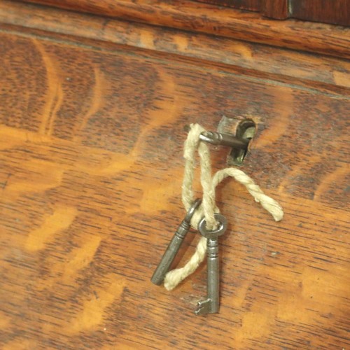 3154 - A late 19th century oak bureau bookcase, having two leaded glazed doors above a fitted interior and ... 