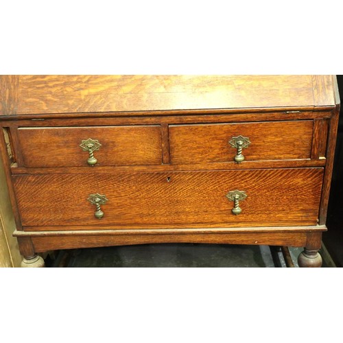 3154 - A late 19th century oak bureau bookcase, having two leaded glazed doors above a fitted interior and ... 