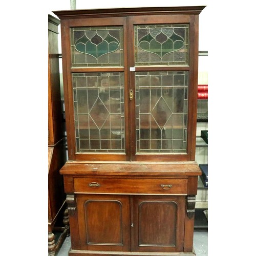 3155 - A Victorian bookcase, having two doors glazed with stained glass, three shelves raised above a sideb... 