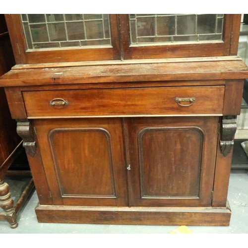 3155 - A Victorian bookcase, having two doors glazed with stained glass, three shelves raised above a sideb... 