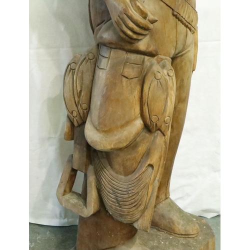 388 - Large carved wood cowboy figure with Lee belt buckle, H: 180 cm. Two cracks to hat, small crack wher... 