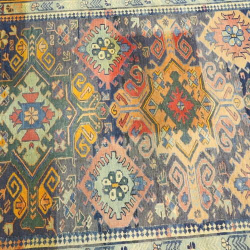 3097 - A large Sumak Kelim knotted rug, having geometric designs against a blue ground, 280 x 160 cm. No vi... 