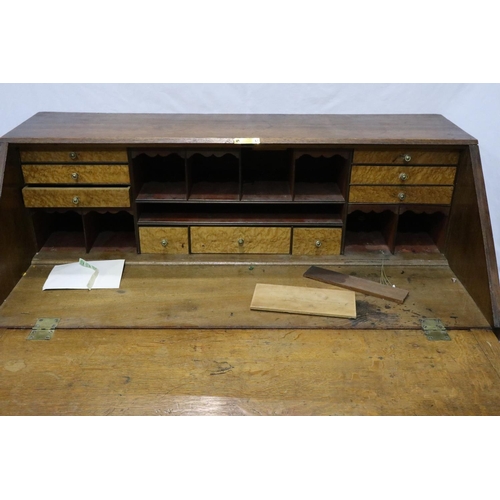 3060 - A George III oak bureau, a fitted interior of drawers and pigeon holes above a four drawer base, 102... 