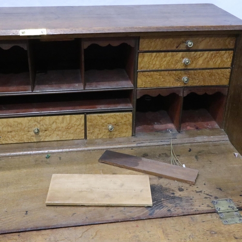 3060 - A George III oak bureau, a fitted interior of drawers and pigeon holes above a four drawer base, 102... 