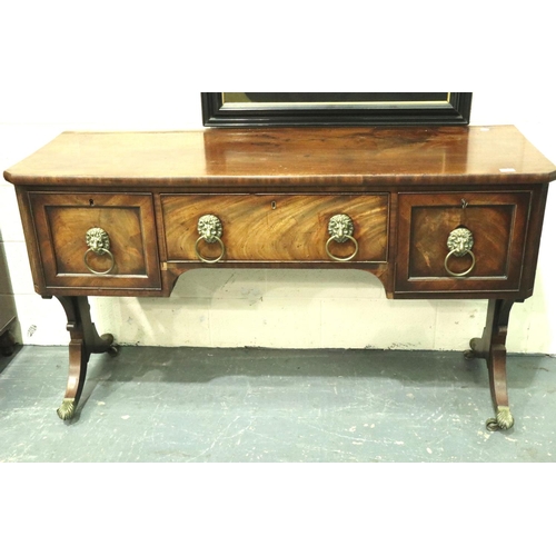 3107 - An early 19th century walnut buffet, having two cupboards flanking a single drawer, lion mask handle... 