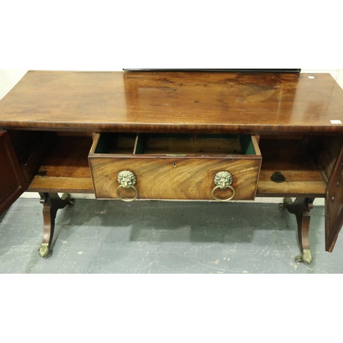 3107 - An early 19th century walnut buffet, having two cupboards flanking a single drawer, lion mask handle... 