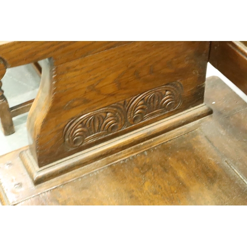 3116 - An early 20th century oak monks bench with tilting top and carved in the Jacobean manner, 106 x 50 x... 