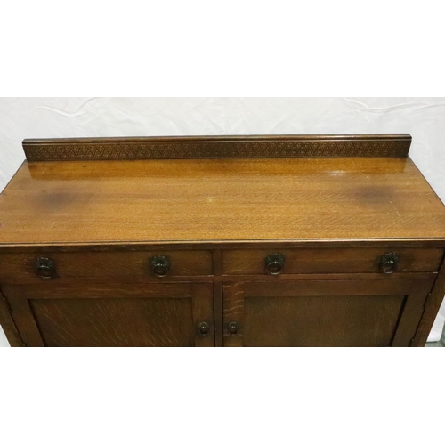 3119 - An early 20th century oak sideboard of two short drawers above a cupboard base with carved frieze, 1... 