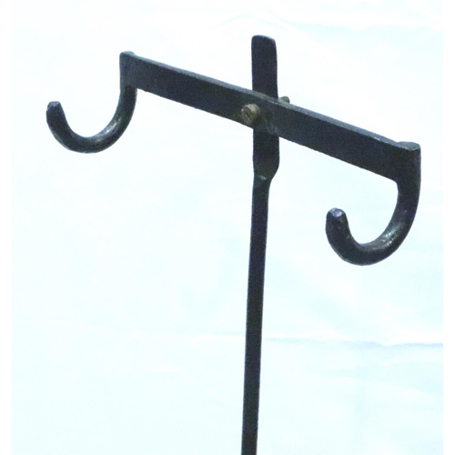 3118 - An Edwardian gentlemans height adjusting apparel stand with two hooks, raised on a cast iron support... 