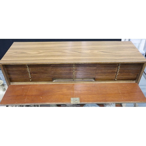 3131 - A coin collectors chest, fitted with a multitude of drawers, having a drop-down locking front (with ... 