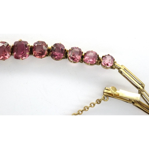 86 - Presumed gold (unmarked) delicate bracelet set with eleven graduated amethyst stones, with guard cha... 