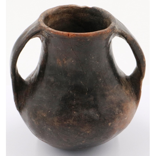 3005 - A Han Dynasty black pottery amphora vessel, the body stylised with twin handles, H: 13 cm. Crack to ... 