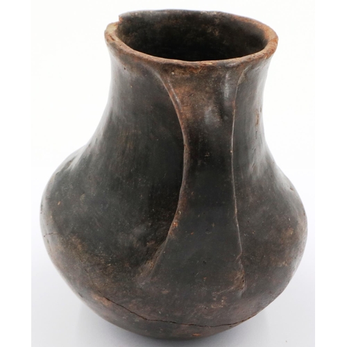 3005 - A Han Dynasty black pottery amphora vessel, the body stylised with twin handles, H: 13 cm. Crack to ... 