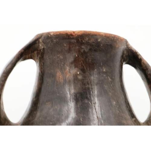 3005 - A Han Dynasty black pottery amphora vessel, the body stylised with twin handles, H: 13 cm. Crack to ... 