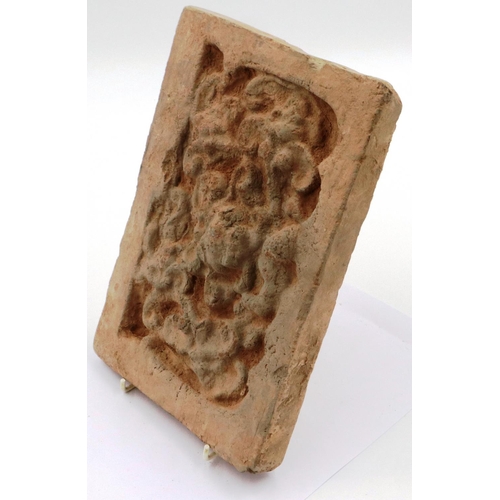 3006 - A Song Dynasty red clay tile, decorated in relief with a stylised front-facing dragon, 18 x 26 cm. P... 