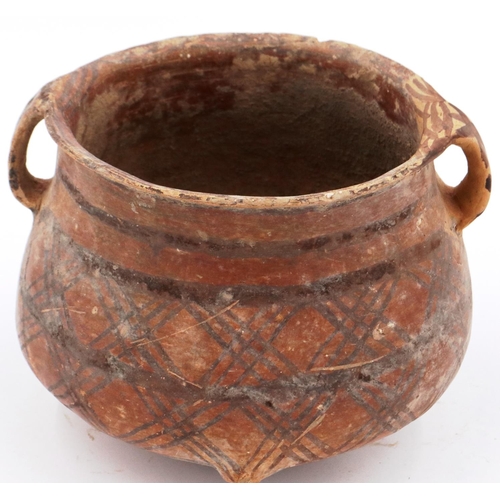 3009 - A Neolithic period terracotta pot, with flared rim and two loop handles; the upper body painted with... 