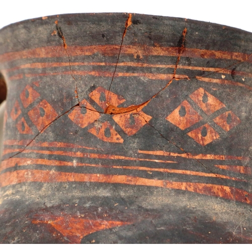 3027 - A Neolithic period painted terracotta twin handled pot, decorated with geometric designs, painted ma... 