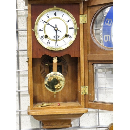 412 - A 20th century oak cased wall clock, chiming on a gong with glazed display door, H: 53 cm, working a... 