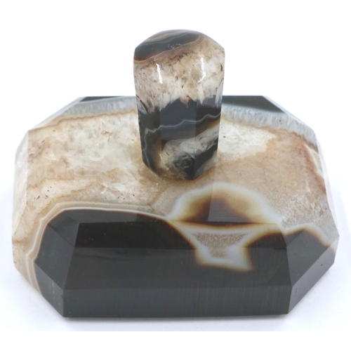 3081 - A banded and laced brown manao agate paperweight, being a tapering block surmounted with an octagona... 