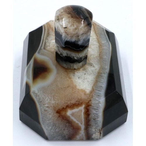 3081 - A banded and laced brown manao agate paperweight, being a tapering block surmounted with an octagona... 