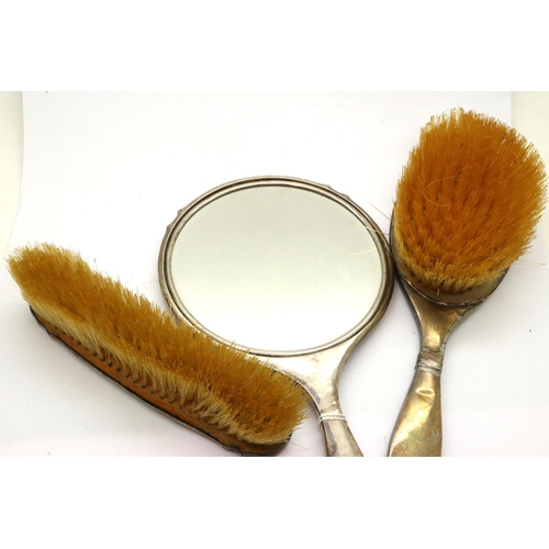 149 - Two hallmarked silver backed brushes and a mirror, Birmingham assay. P&P Group 2 (£18+VAT for the fi... 