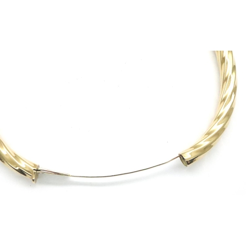 5A - 9ct gold snap bangle, D: 70 mm, 16.8g. Clasp is smooth with minimal wobble when open, closes with a ... 